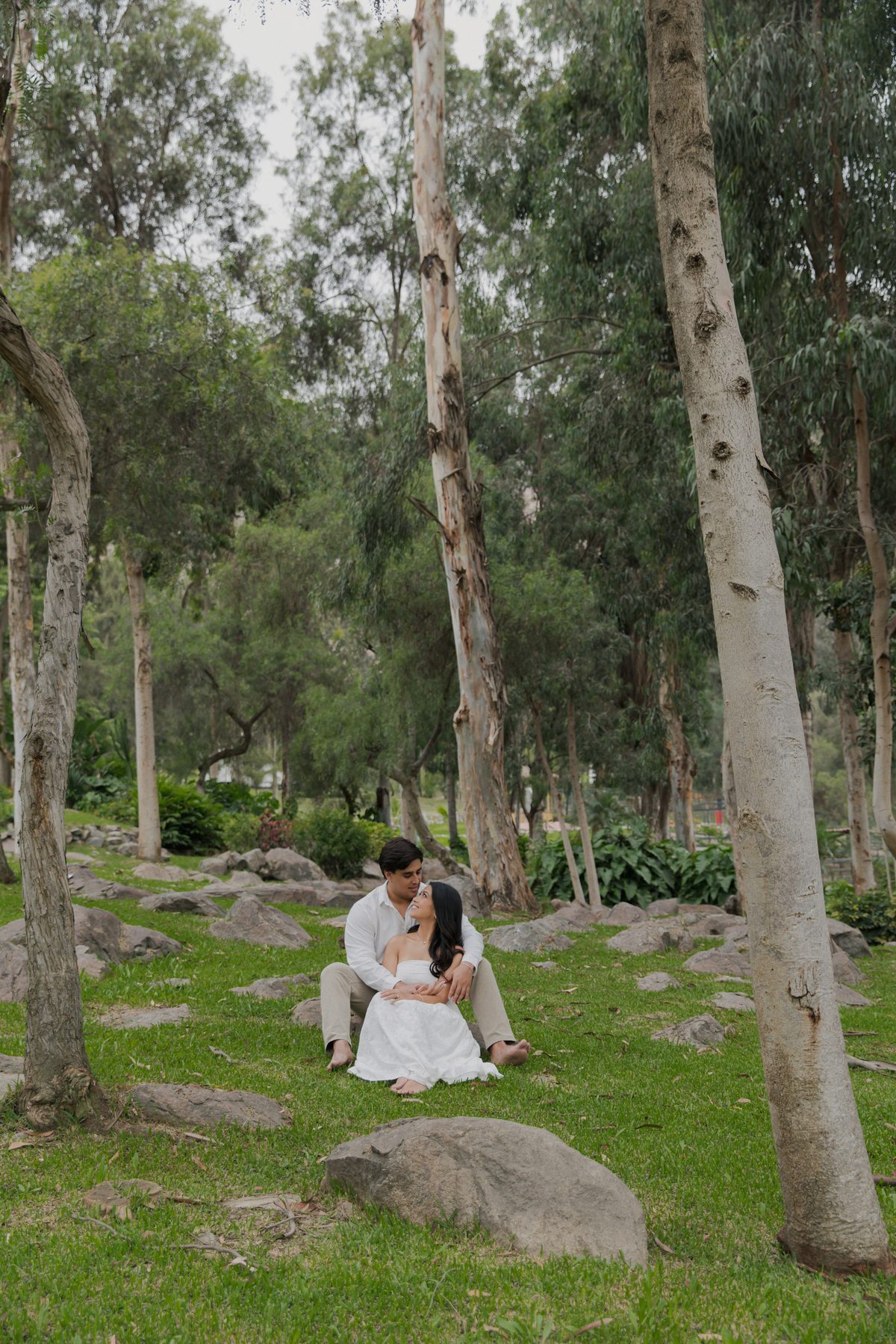 Cristell y Alvaro sentados bajo los árboles